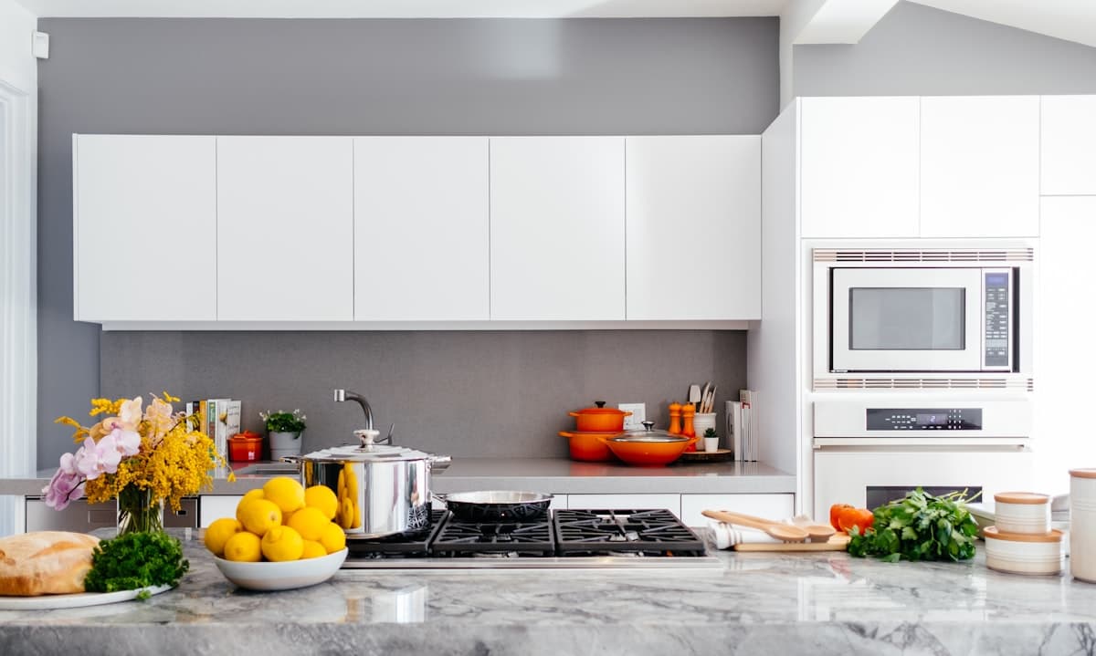 Kitchen with white sprayed cabinets and gray accent wall